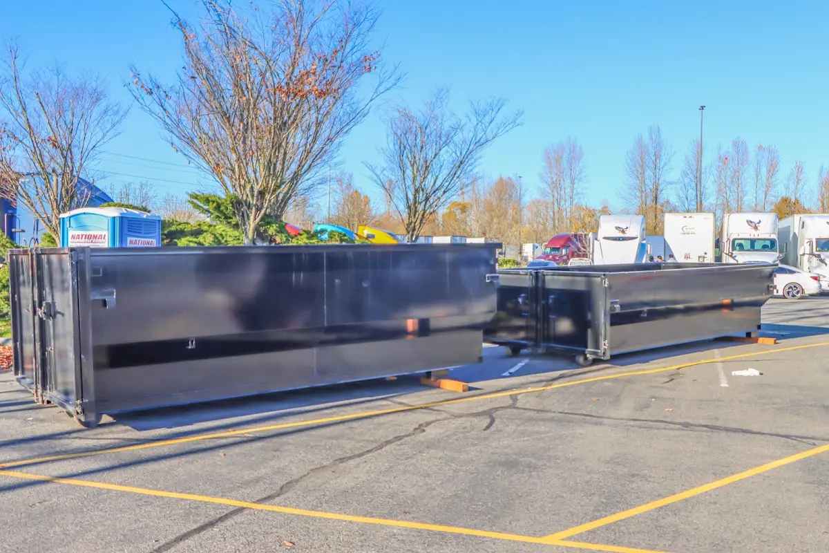 Professional dumpster rental service with roll-off container on residential driveway in Tenafly